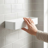 Mano presionando el estante ShowerGrip Corner contra el azulejo mostrando su tamaño